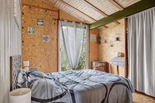a bedroom with a bed and a large window at Chalet Sein Dans Parc Résidentiel in Pléneuf-Val-André