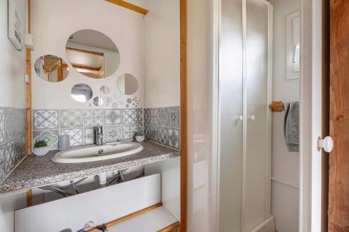a bathroom with a sink and a mirror at Chalet Sein Dans Parc Résidentiel in Pléneuf-Val-André