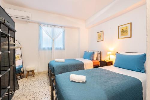 a hotel room with two beds and a tv at Katia's Home in Rhodes Town
