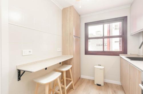a kitchen with a counter and stools in it at Apartamento Bilua in Luanco