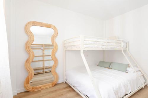a bedroom with a bunk bed and a mirror at Apartamento Bilua in Luanco