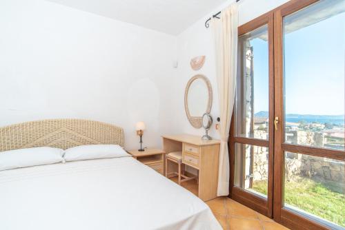 a bedroom with a bed and a large window at Villetta Caron in Olbia