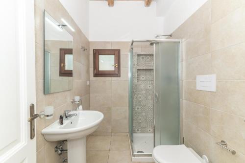 a bathroom with a sink toilet and a shower at Villetta Caron in Olbia
