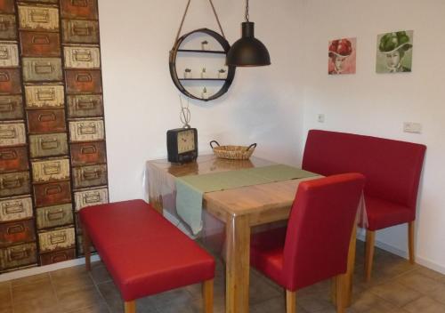a dining room with a table and two red chairs at Ferienwohnung Pusteblume in Forbach