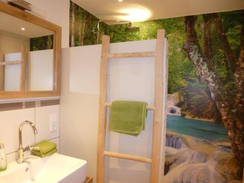 a bathroom with a shower with a painting on the wall at Ferienwohnung Pusteblume in Forbach