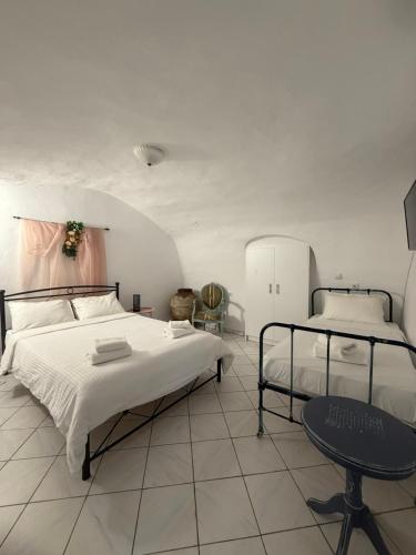 a bedroom with two beds and a table in it at Mani Tsopakas Residences Nest studio in Kafióna
