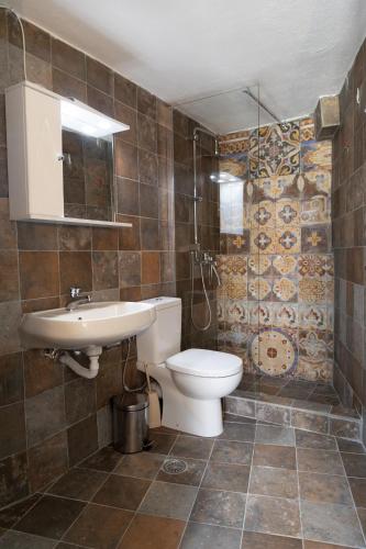 a bathroom with a toilet and a sink at Mani Tsopakas Residences Nest studio in Kafióna