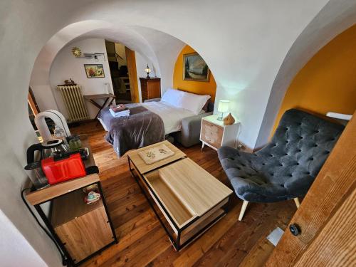 a bedroom with a bed and a couch and a table at La Torre Medievale in Triora