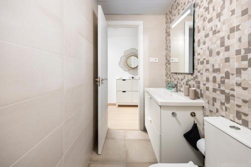 a white bathroom with a sink and a mirror at Capricho Torre del mar in Torre del Mar