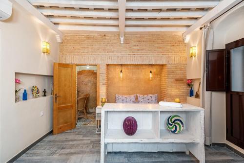 a room with a white table and a brick wall at Rosa in Vejer de la Frontera