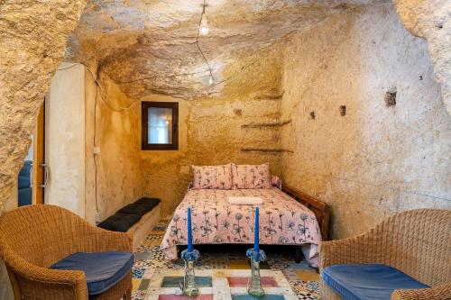 a bedroom in a cave with a table and two chairs at Rosa in Vejer de la Frontera