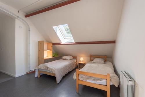 a attic bedroom with two beds and a skylight at Chalet Confortable 14 voyageurs in Urdos