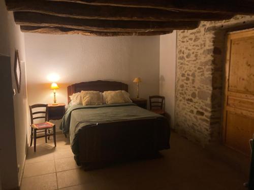 a bedroom with a bed and a stone wall at Chez Bonneau in Nantiat