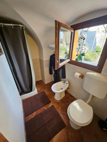 a bathroom with a toilet and a sink and a window at La Torre Medievale in Triora