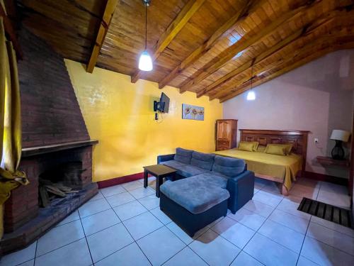 a living room with a couch and a bed at Cabañas Rosy in Mazamitla