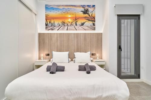 a bedroom with a large white bed with two pillows at Aptos Turísticos Playa Marinsa in Torre del Mar