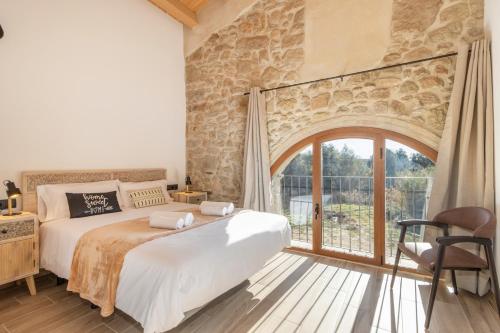 a bedroom with a bed and a large window at El Molí de Can Feliu in Navés