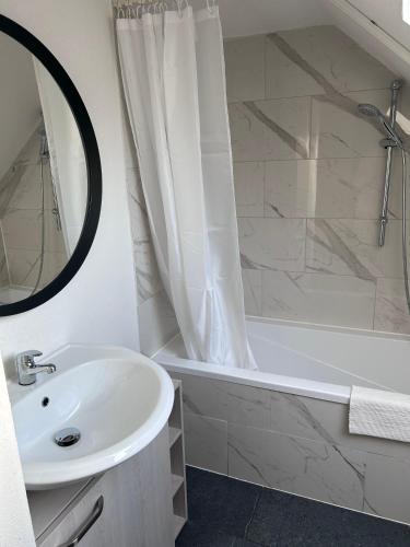 a bathroom with a sink and a bath tub with a mirror at Modern Apartment in Bebra