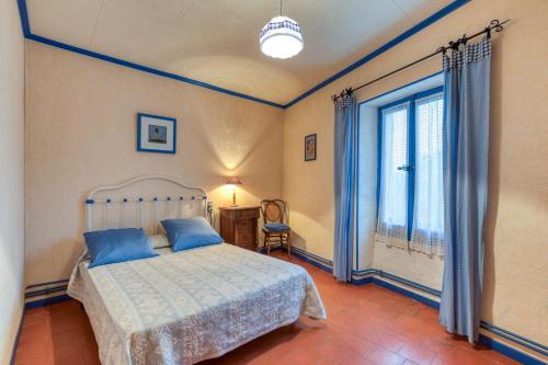 a bedroom with a bed and a large window at La Coustouline in Lacoste