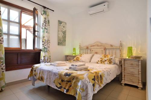 a bedroom with a bed and a dresser and window at Serendipity in Playa Blanca