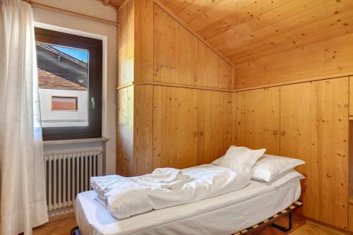 a bed in a wooden room with a window at Apartment Holzsuite in Fondo