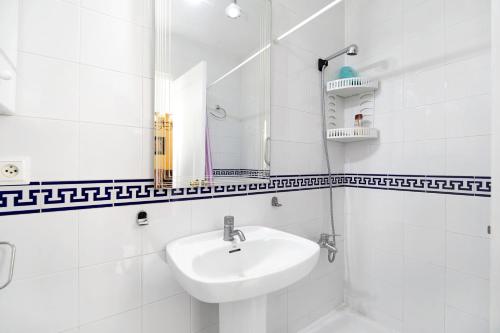a white bathroom with a sink and a mirror at Espiritu Santo Velero 54 in Sanlúcar de Barrameda