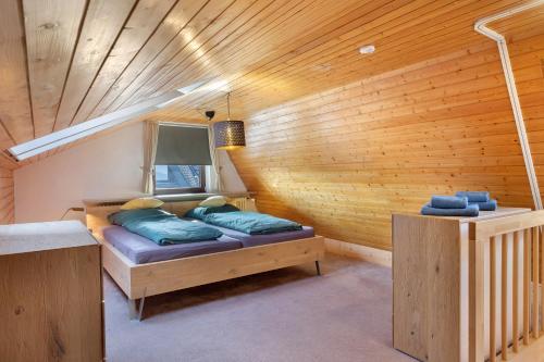 a bedroom with a bed in a wooden wall at Maisonette auf 1000m mit Sauna in Schönwald