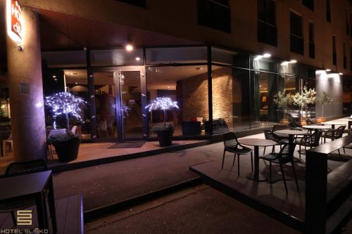 - un restaurant avec des tables et des chaises la nuit dans l'établissement Hotel Sliško, à Zagreb