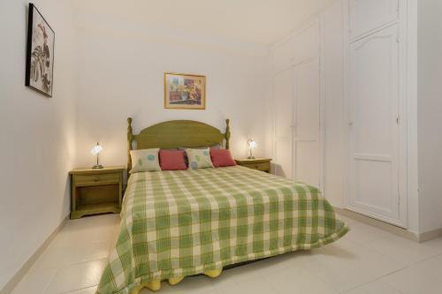 a bedroom with a bed with a green and yellow blanket at Casa Paradise Jannest in Adeje