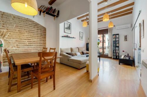 a dining room and living room with a brick wall at Plaça la Font in Tarragona