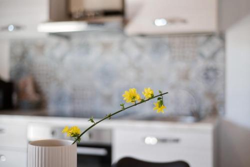 a vase with yellow flowers in a kitchen at Appartamenti Villafiorito in Lazise