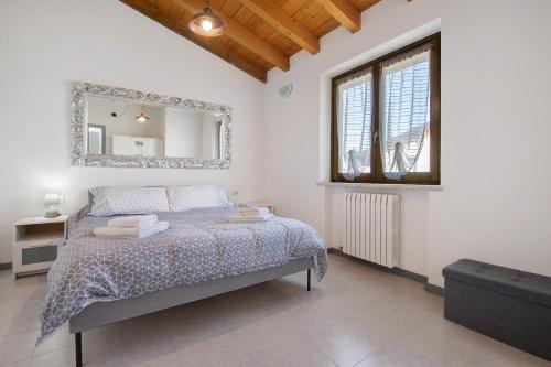 a bedroom with a bed with a mirror on the wall at Appartamenti Villafiorito in Lazise