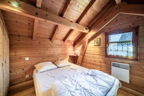 a bedroom with a bed in a wooden room at Chalet 6p Confort - Les Cerfs in Verchaix