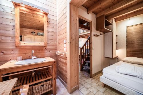 a bathroom with a sink and a bed in a room at Chalet 6p Confort - Les Cerfs in Verchaix
