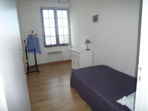 a bedroom with a bed and a dresser and two windows at Villa Pigna in Pigna