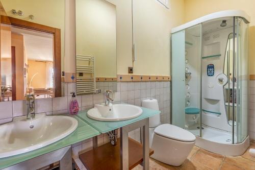 a bathroom with two sinks and a shower and a toilet at Alpine Sierra Nevada in Sierra Nevada