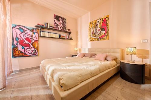 a large bed in a room with paintings on the walls at Rosamare - Follonica in Follonica