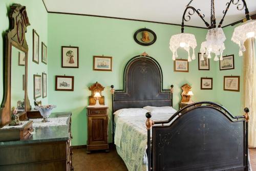 a bedroom with a large bed and green walls at Clematis in Cisterna dʼAsti