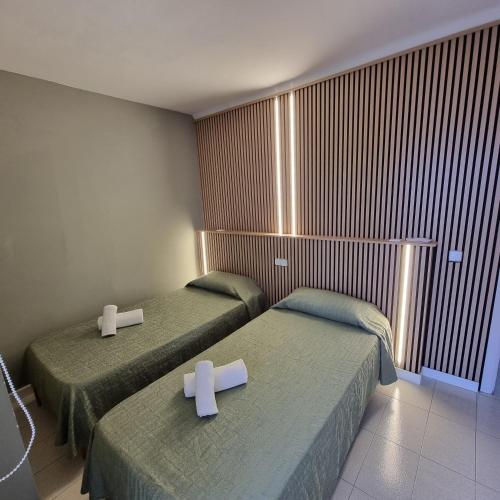 two beds in a room with two crosses on them at Apartamento Portosun Caracol in Portocolom