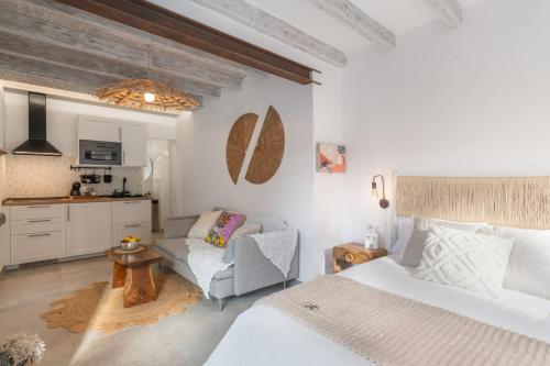 a bedroom with a bed and a couch and a kitchen at El Jable Rentals in Arrieta