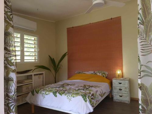 a bedroom with a bed and a dresser and a window at Gîte KAZ' A TYKA jacuzzi privatif in Saint-François