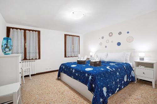 a bedroom with a bed with a blue comforter at Ca' Della Torre, a 5 min da Rialto in Venice