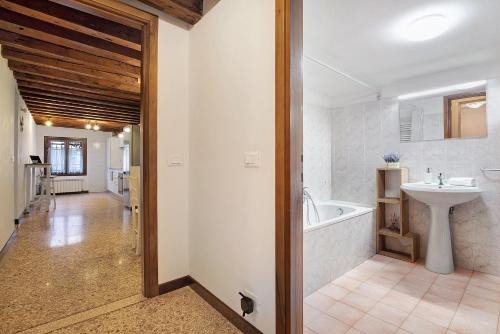 a bathroom with a bath tub and a sink at Ca' Della Torre, a 5 min da Rialto in Venice