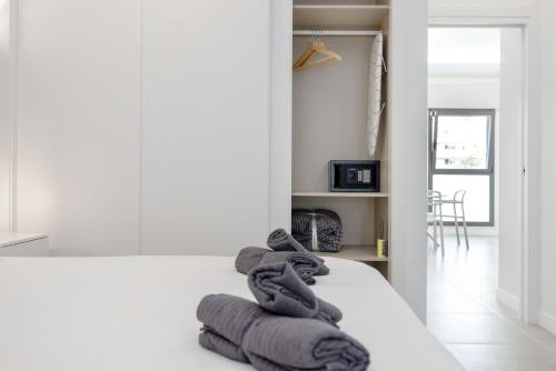 a pile of towels sitting on top of a bed at Aptos Turísticos Playa Marinsa in Torre del Mar