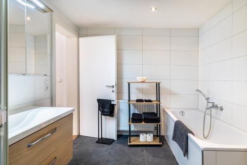 a bathroom with a tub and a sink and a bath tub at Apartments Winder 2 in Lustenau