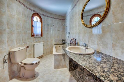 a bathroom with a toilet and a sink and a mirror at Villa Speranza by Easy Brava in Calonge