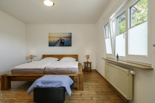a bedroom with two beds in a room with windows at Ferienwohnung Eberle in Eriskirch