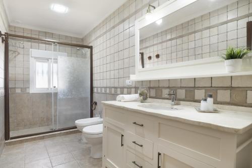 a bathroom with a toilet and a sink and a shower at Chalet Los Paul in Chiclana de la Frontera