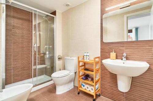 a bathroom with a toilet and a sink and a shower at El ático del Oasis in Salobreña