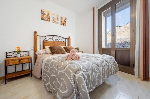 a bedroom with a bed with two teddy bears on it at Apartamentos El Compromiso in Caspe